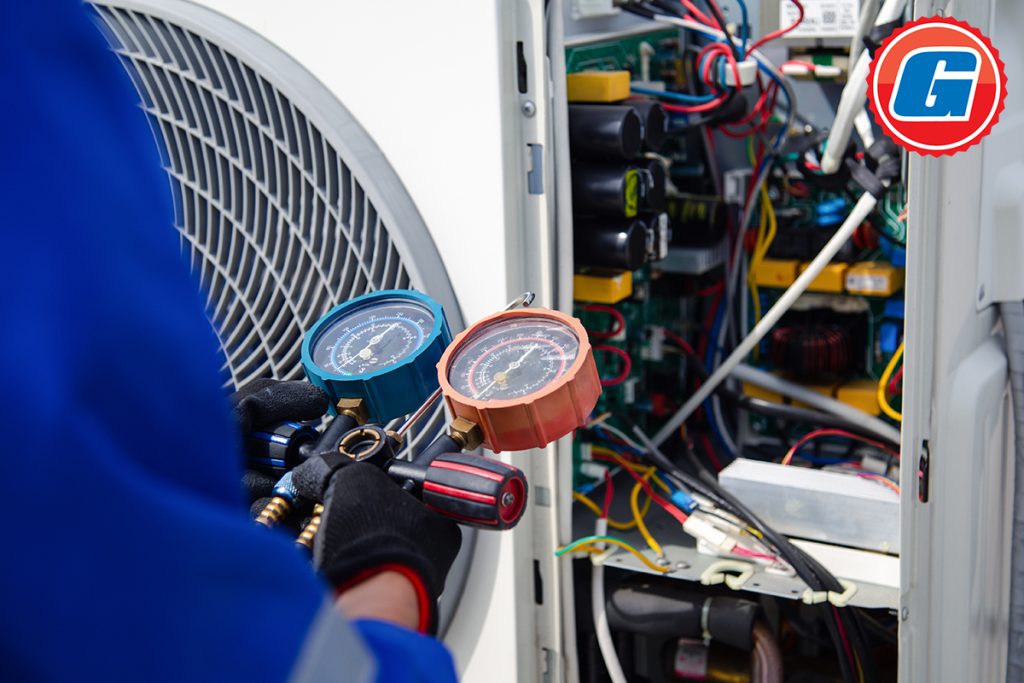 Air conditioner service .The air conditioner technician is using a gauge to measure the refrigerant pressure.
